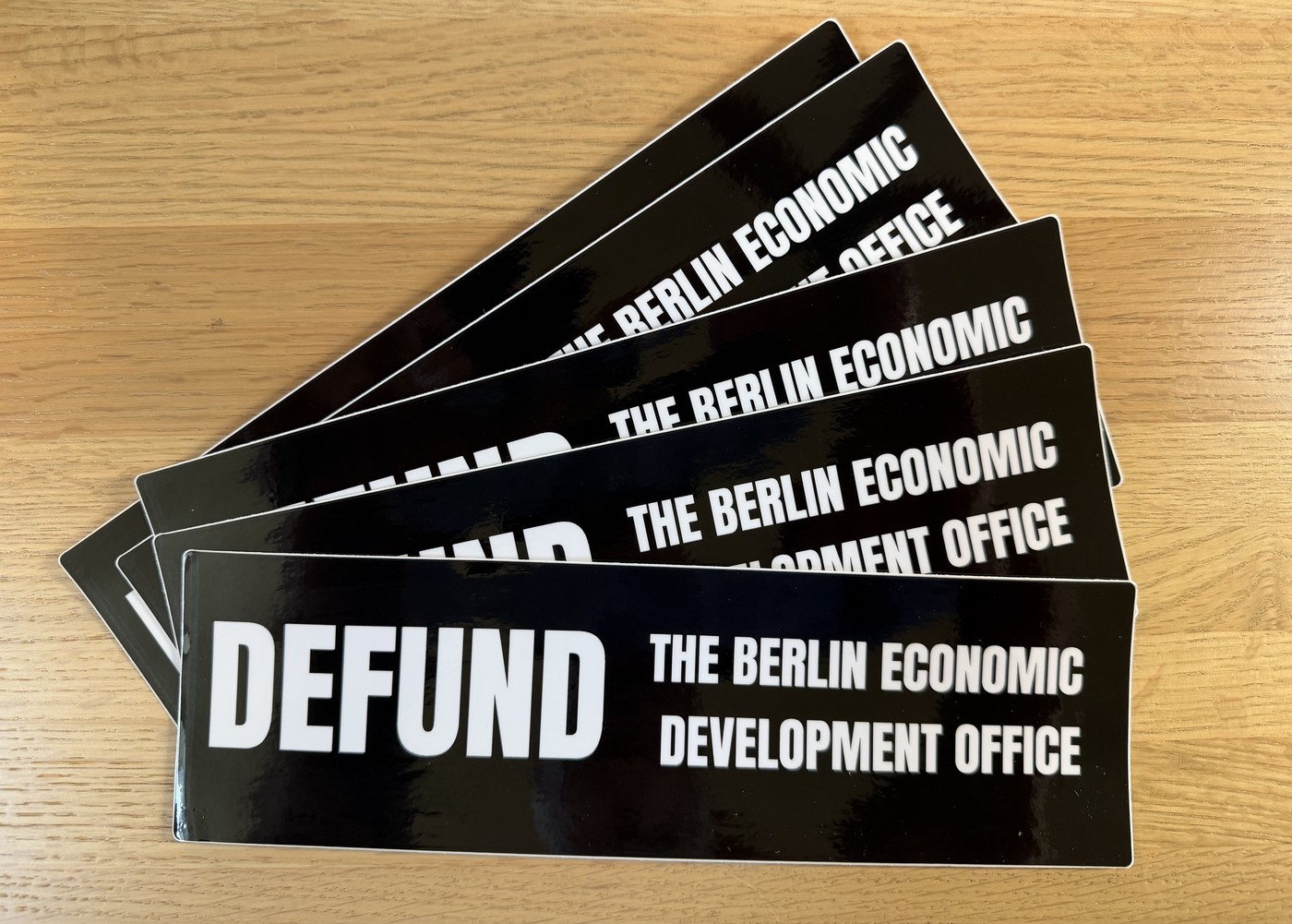 Black bumper sticker reading Defund the Berlin Economic Development Office